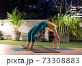 Asian woman do yoga in city at night 73308883