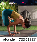 Asian woman do yoga in city at night 73308885