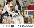 Waitress with face mask prepare order for curbside pick up and takeout. 73308888