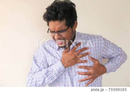 young asian man suffering pain in heart and holding chest with hand  73309165