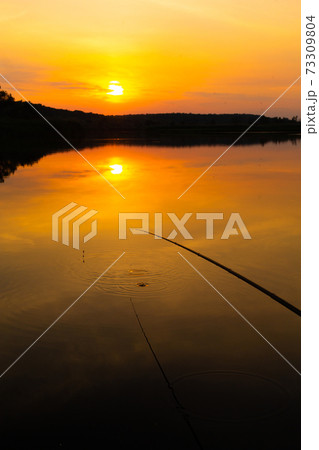 Natural landscape. Sunset over water, reflection of the sun and clouds in the water 73309804