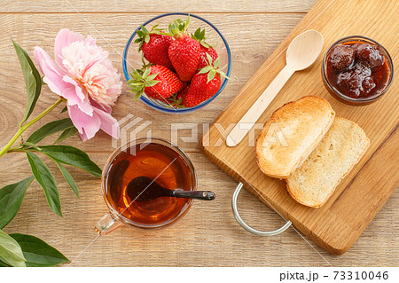 Traditional homemade strawberry jam in bowl, fresh berries with toast on wooden background. Traditional homemade strawberry jam in bowl, fresh berries with toast on wooden background. 73310046