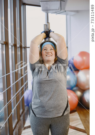 Adult fat woman doing gymnastics at the gym 73311489