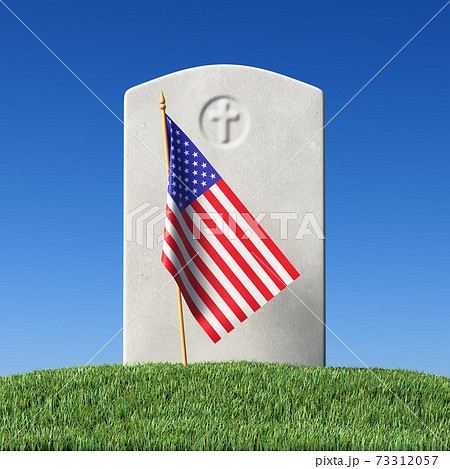 Gravestone and small American flag on green grass under blue sky Gravestone and small American flag on green grass under blue sky 73312057