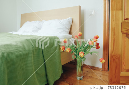 Bouquet of red yellow tulips in a bedroom on the background of the bed. Bouquet of red yellow tulips in a bedroom on the background of the bed. 73312076