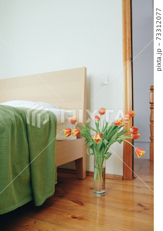 Bouquet of red yellow tulips in a bedroom on the background of the bed. Bouquet of red yellow tulips in a bedroom on the background of the bed. 73312077