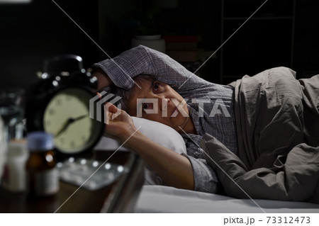 Depressed senior woman lying in bed cannot sleep from insomnia 73312473