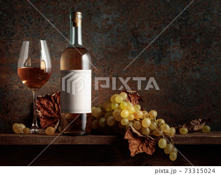 Wine with grapes and dried up vine leaves. 73315024