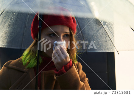 Woman sneezing at the paper napkin 73315681