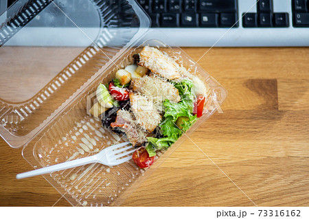 Delivery of takeout meal salad to workplace 73316162
