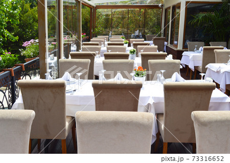 Ornate empty dining tables in a modern restaurant ready to serve 73316652