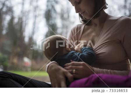 Young mother breastfeeding her tiny baby 73316653