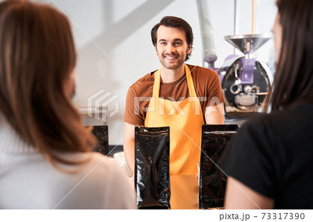 Barista looking at the two client Barista looking at the two client 73317390