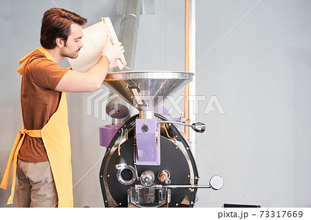 Worker pouring coffee beans in case Worker pouring coffee beans in case 73317669