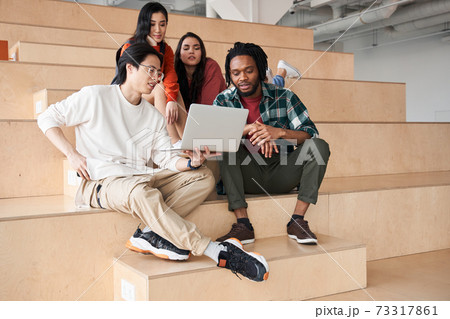 Group of international students looking at laptop at school Group of international students looking at laptop at school 73317861
