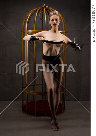 Sexy woman with whip standing near cage - Stock Photo [73318677] - PIXTA