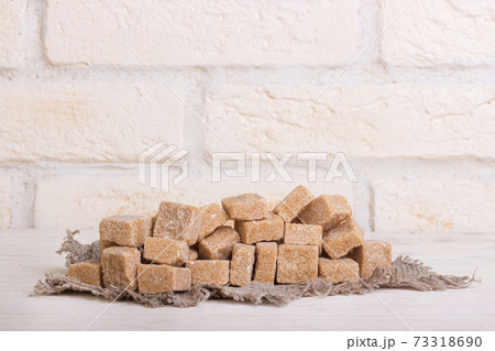 Pricked brown cane sugar on linen cloth 73318690