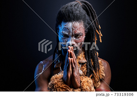 ethnic black male model doing ritual isolated over black background ethnic black male model doing ritual isolated over black background 73319306