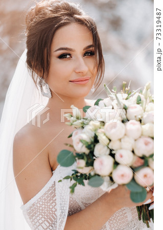 Beautiful bride in a wedding dress with a bouquet on the top of the salt mountains. A stunning young bride with curly hair . Wedding day. . Beautiful portrait of the bride without the groom. Beautiful bride in a wedding dress with a bouquet on the top of the salt mountains. A stunning young bride with curly hair . Wedding day. . Beautiful portrait of the bride without the groom. 73319487