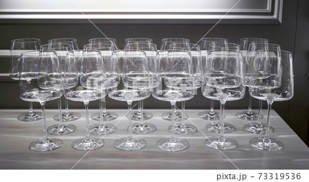 lot of wine glasses in a row. Empty clean glasses wine, water in a kitchen of a restaurant or cafe. Catering buffet in restaurant room. Concept preparing for celebration lot of wine glasses in a row. Empty clean glasses wine, water in a kitchen of a restaurant or cafe. Catering buffet in restaurant room. Concept preparing for celebration 73319536
