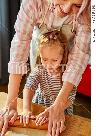 mom showing preschool daughter how to roll out dough for pie or cookies mom showing preschool daughter how to roll out dough for pie or cookies 73319999