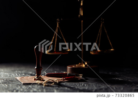 Law and justice concept. Scales of justice, envelope with seal and wooden stamp on a table 73320865