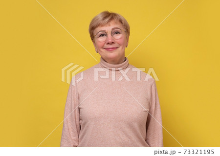 Aged caucasian lady with glasses posing to the camera smiling. 73321195