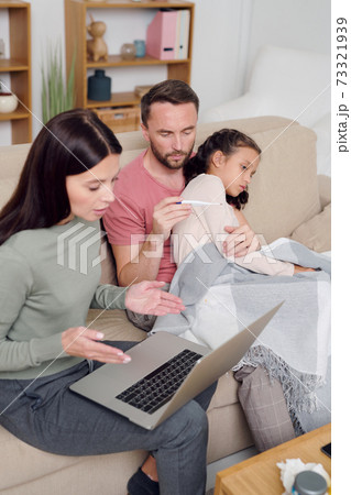 Young woman describing symptoms of sick little daughter to online doctor Young woman describing symptoms of sick little daughter to online doctor 73321939