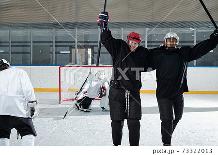 Excited hockey players in sports uniform expressing joy after successful play Excited hockey players in sports uniform expressing joy after successful play 73322013