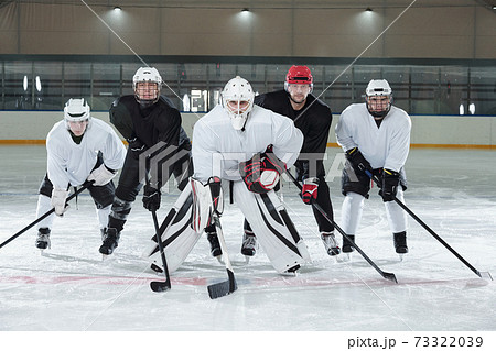 Professional hockey players bending forwards while standing on ice rink 73322039
