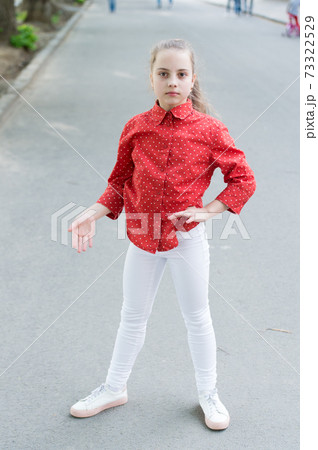 Getting a bit casual. Casual look of cute little child. Small girl wearing casual and spotted red shirt. Adorable kid dressed for a casual summer day outdoor Getting a bit casual. Casual look of cute little child. Small girl wearing casual and spotted red shirt. Adorable kid dressed for a casual summer day outdoor 73322529