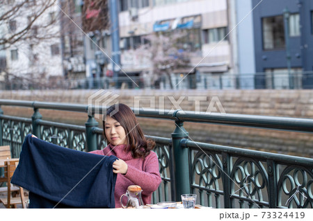 オープンカフェで膝掛けを準備する女性 オープンカフェで膝掛けを準備する女性 73324419