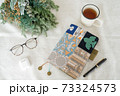 テーブルの上に置かれたメガネと紅茶と手帳,ドライフラワー 73324573