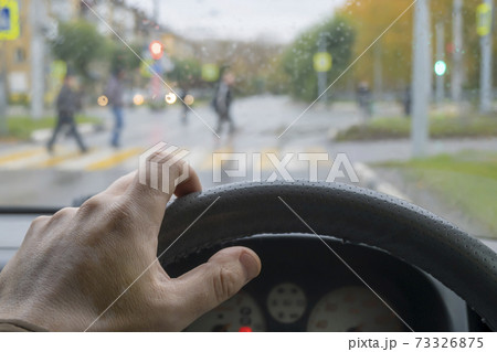 driver's hand on the steering wheel of the car in cloudy weather driver's hand on the steering wheel of the car in cloudy weather 73326875
