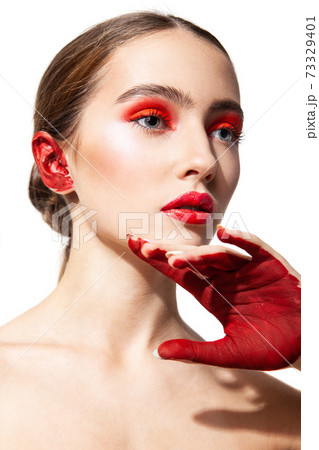Woman with red makeup and painted hand 73329401