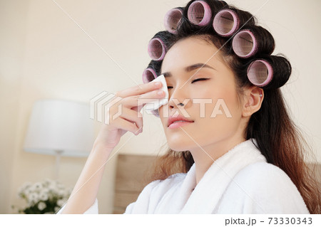 Woman taking off make-up 73330343