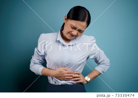Asian woman was sick with stomach ache. 73330474