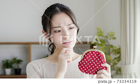 財布を持つ若い女性 73334319
