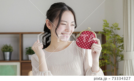 財布を持つ若い女性 73334327