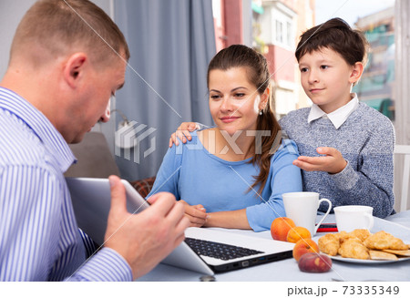 Happy family with laptop discussing their plans 73335349