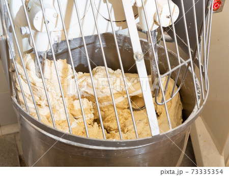Kneading machine preparing dough in baker workshop 73335354