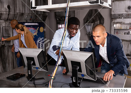 Men in panic looking for a solution on the computer in quest room Men in panic looking for a solution on the computer in quest room 73335596