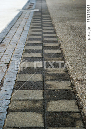 濡れて交互に色がついた歩道の模様 73336343