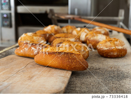 bread on wooden baking shovel in bakery 73336418
