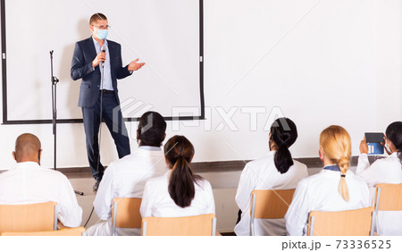 Male coach giving speech at conference hall 73336525
