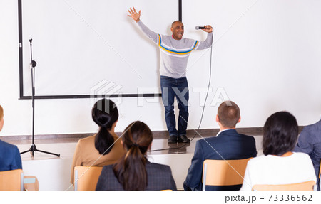 Excited Hispanic preacher giving motivational speech from stage Excited Hispanic preacher giving motivational speech from stage 73336562