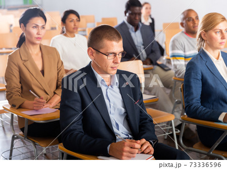 Man listening to speaker on business training in conference hall Man listening to speaker on business training in conference hall 73336596