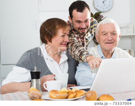 Parents and son watching photos 73337004