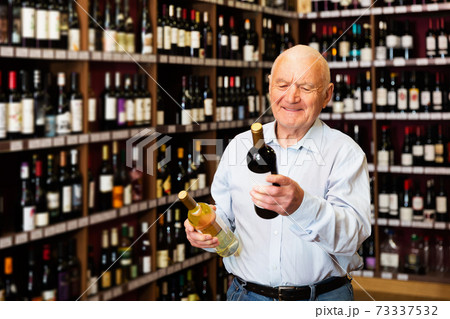 man chooses between red and white wine 73337532