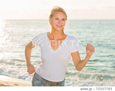 Female in white T-shirt is jogging 73337705
